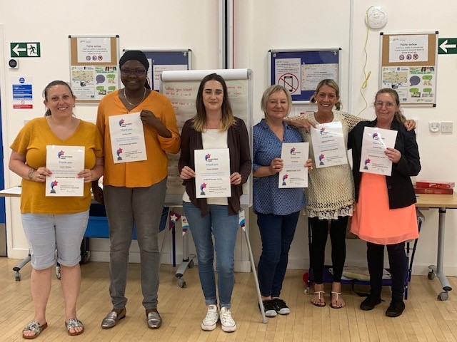 Group of volunteers receiving their certificates following in-house training