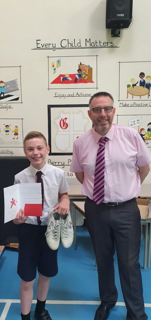 Pupil receives football boots as part of the Inspire Through Sport mentoring programme